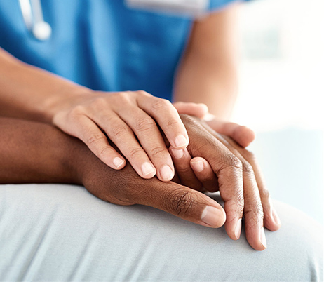 nurse's hand holding a senior patient's hand